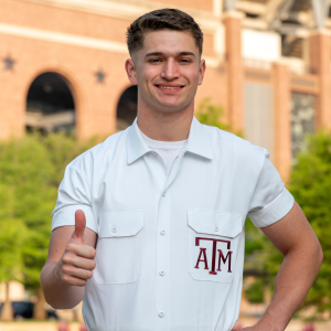 Yell Leader Grayson giving a gig 'em and smiling at the camera.